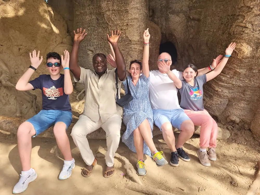 Family and guide at the foot of a baobab